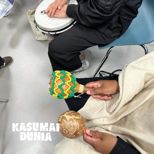 2 paar kinderhanden met maraka's en een djembé
