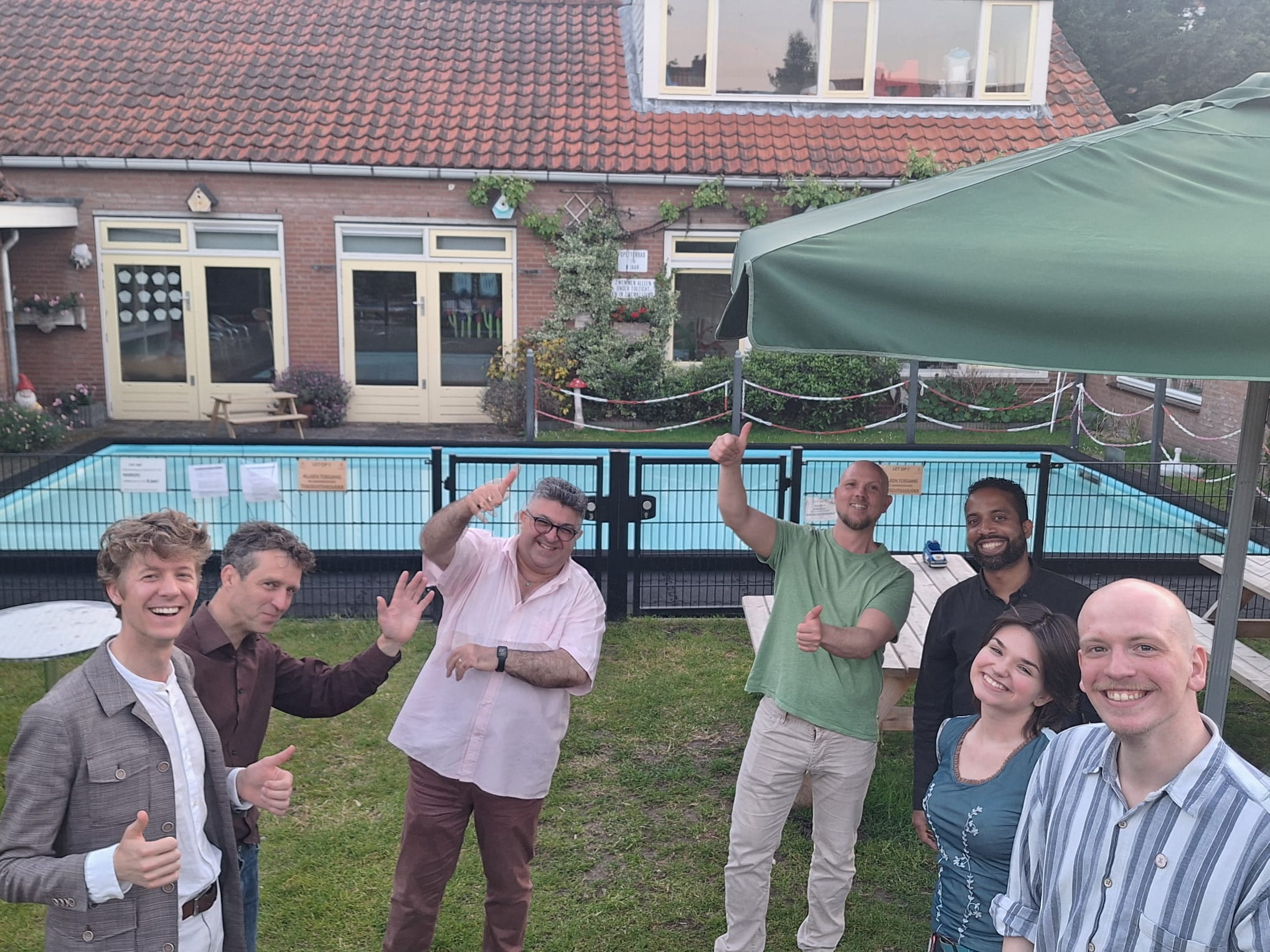 Organistoren van het evenement staan met een glimlach in een half kring