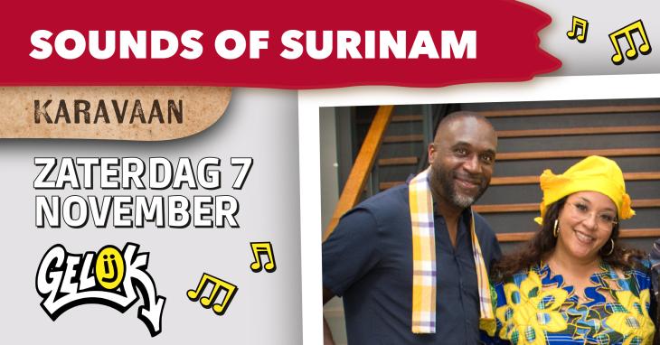 Een man en een vrouw kijken meteen glimlach naar de kamera. Ze dragen allebei kleurrijk Surinaamse accessoires